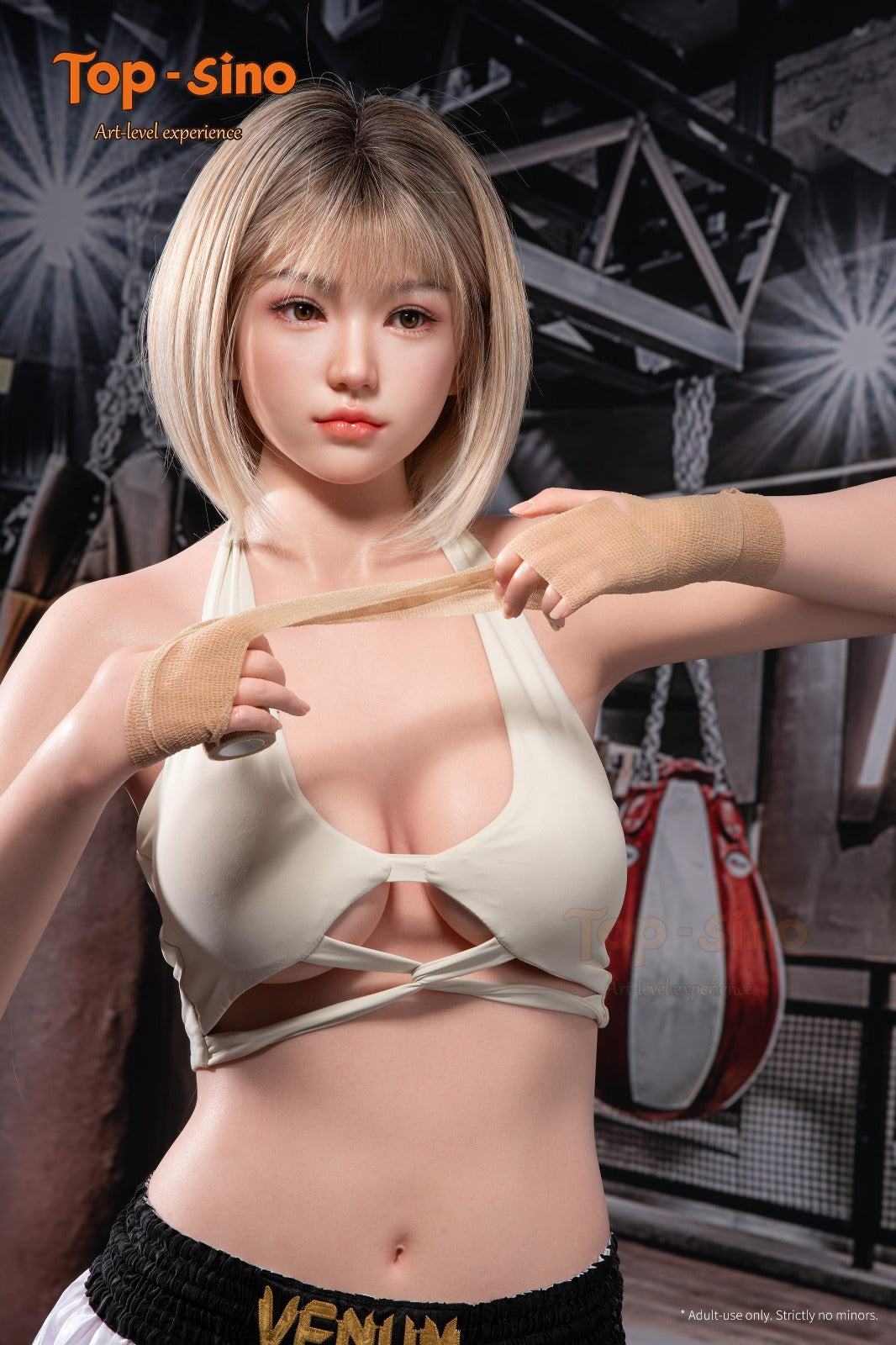 Portrait of the Top Sino Mitu doll, a 171 cm platinum silicone figure with a blonde bob and soft features, wearing a white cross-strap sports bra and hand wraps in a boxing gym setting.