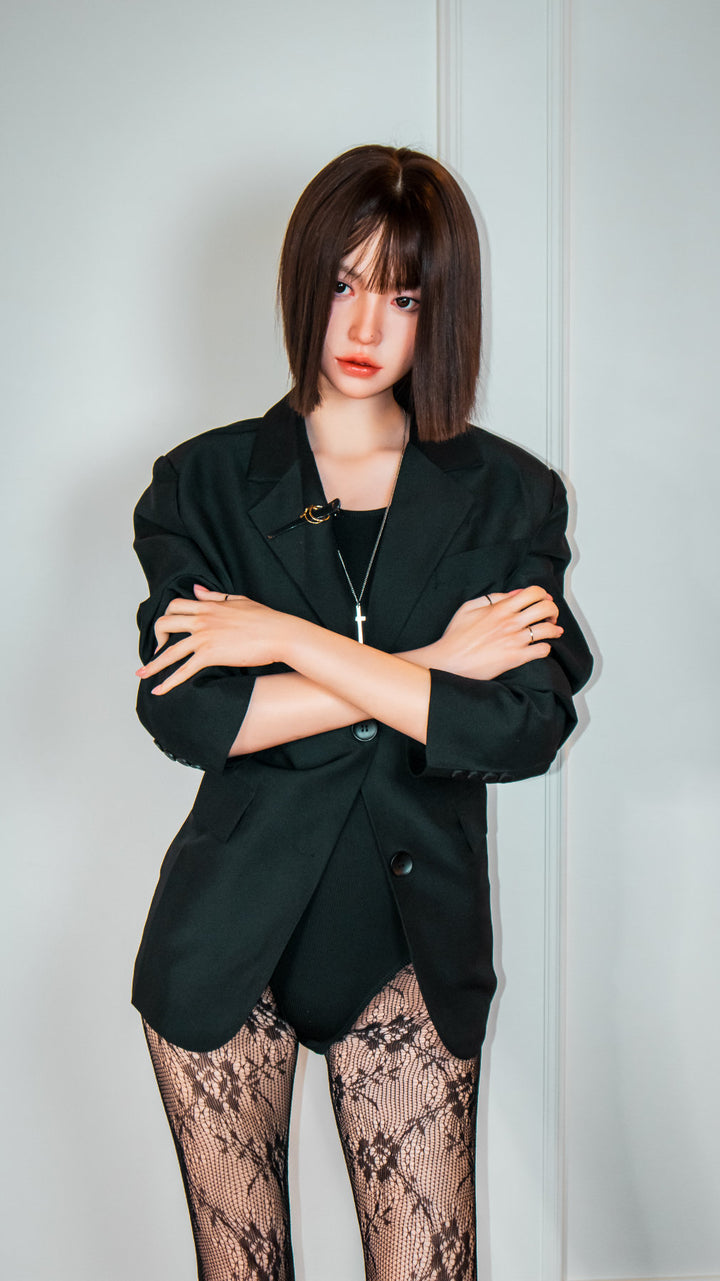 Zelex Doll K-Series 168 cm B Silicone - Arin three-quarter view in black oversized blazer and lace patterned stockings, short dark bob hair, white studio background
