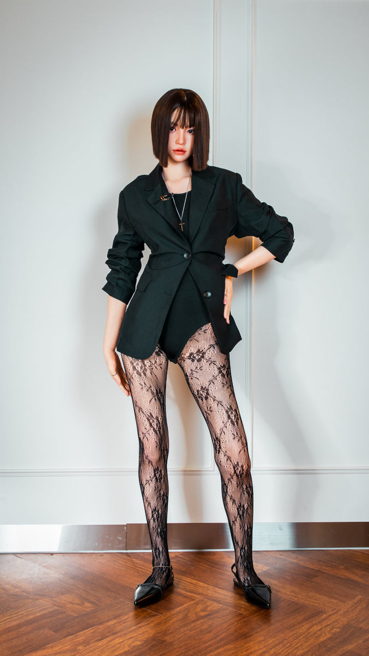 Zelex Doll K-Series 168 cm B Silicone - Arin three-quarter view in open black blazer with red underwear and lace patterned stockings, short dark bob hair, white studio background
