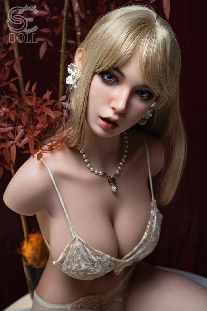 A close-up portrait of the SEDOLL T107 cm H Silicone Torso - Olivia Grant.A, highlighting the realistic facial details, blonde bangs, and pearl jewelry of the silicone mannequin.
